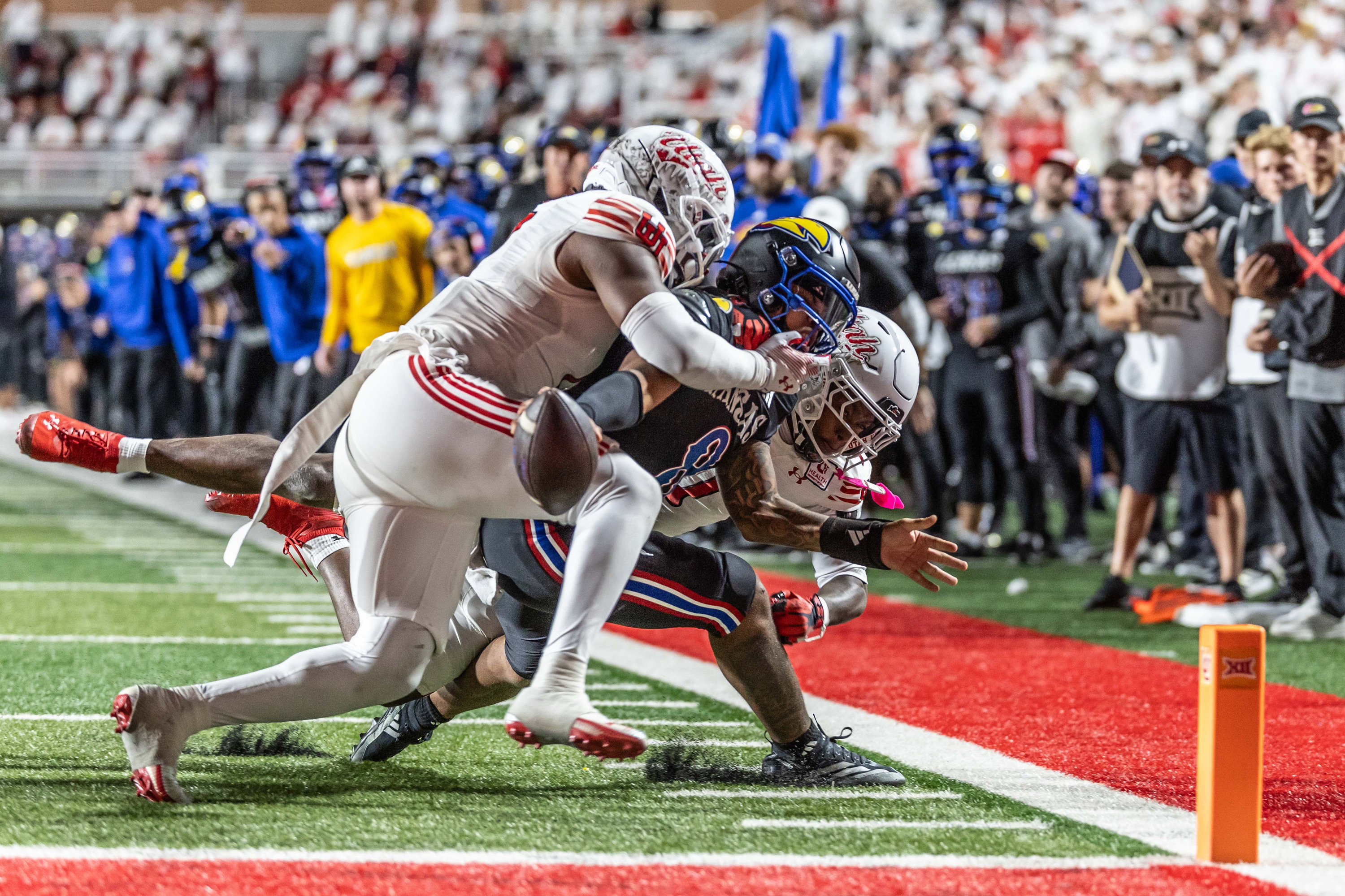 Kansas Jayhawks quarterback Isaiah Marshall (8) is wrapped up at the goal line by Utah Utes safety Rabbit Evans (1) and linebacker Johnathan Hall (7) to prevent a fourth down touchdown during a game at Rice-Eccles Stadium in Salt Lake City on Saturday, Oct. 10, 2026.