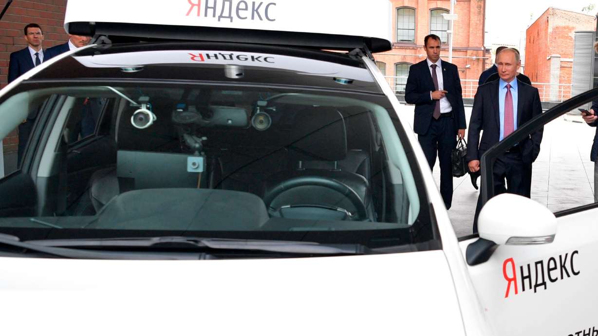 Russian President Vladimir Putin, right, examines the current prototype of an unmanned vehicle during his visits Russia's largest internet search engine Yandex headquarters in Moscow, Russia, on Sept. 21, 2017.