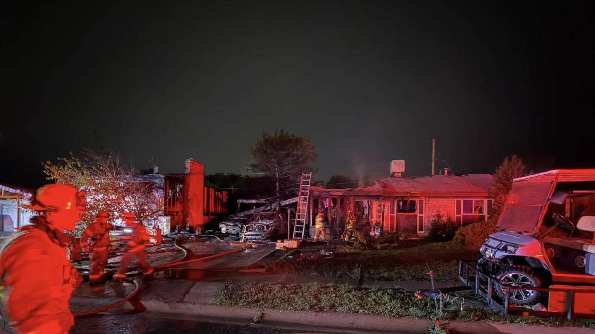 Six people were hospitalized for smoke inhalation after a three-alarm house fire left one home a total loss and severely damaged a neighboring home overnight, fire officials said.