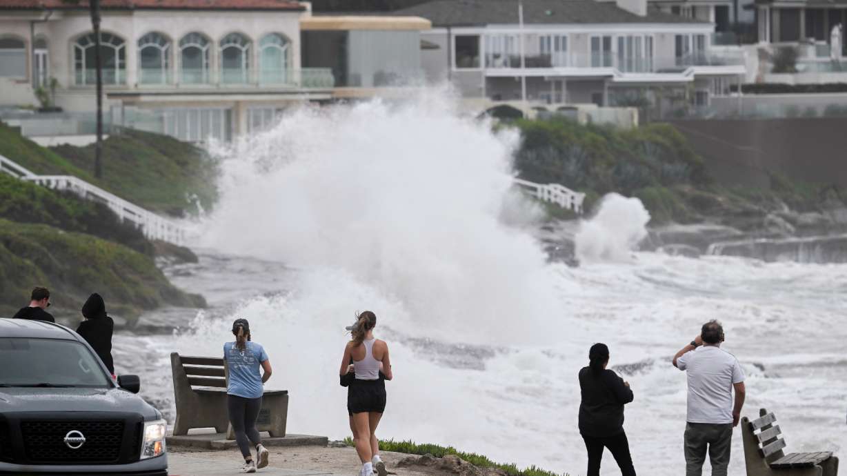 Onlookers watch as storm driven surf batters the bluffs in the La Jolla area of San Diego on Sunday.