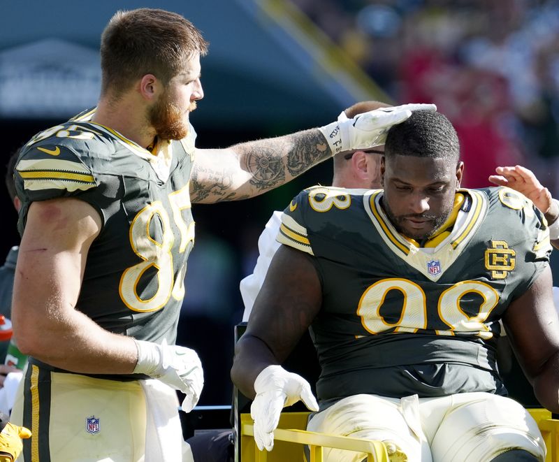 Oct 11, 2026; Green Bay, Wisconsin, USA;  Green Bay Packers tight end Tucker Kraft (85) consoles an injured defensive tackle Javon Hargrave (98) against the Chicago Bears during the gamet Lambeau Field.