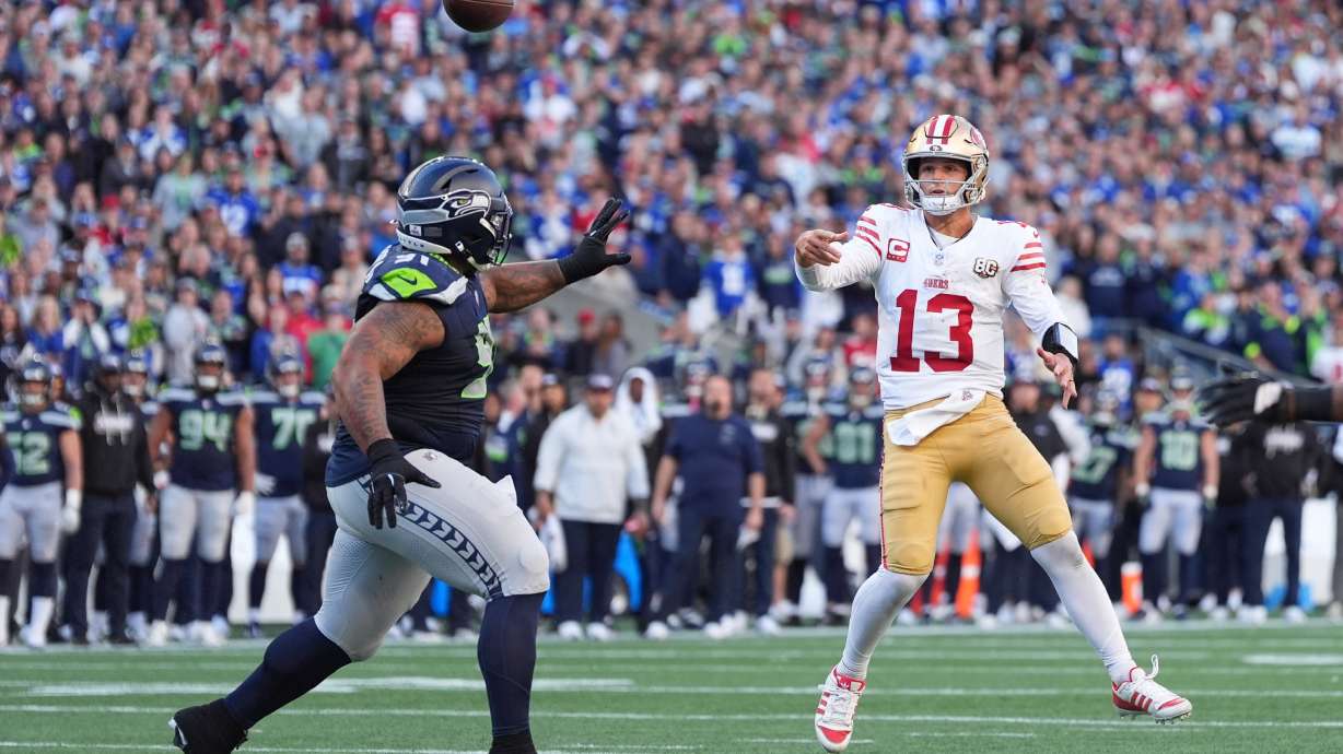 San Francisco 49ers quarterback Brock Purdy (13) throws a 2-point conversion pass as Seattle Seahawks defensive tackle Byron Murphy II (91) tries to apply pressure during the second half of an NFL football game Sunday, Oct. 11, 2026, in Seattle.