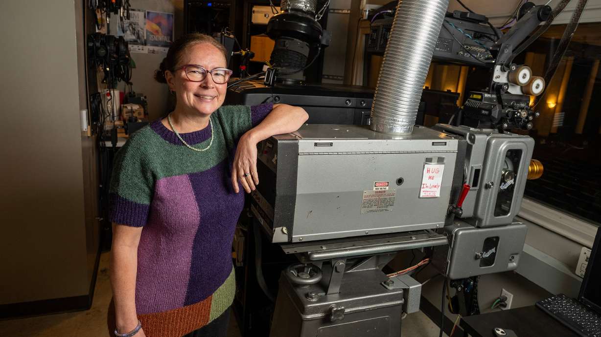 Katharine Wang, Park City Film executive director, poses for photos with an old Century 35mm film projector in Park City on Sept. 30.