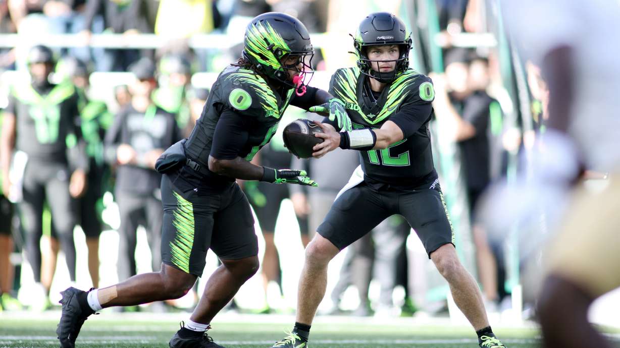 Oregon quarterback Brock Thomas (12) hands off the ball to running back Jordon Davison (0) during the second half of an NCAA college football game against UCLA, Saturday, Oct. 10, 2026, in Eugene, Ore.