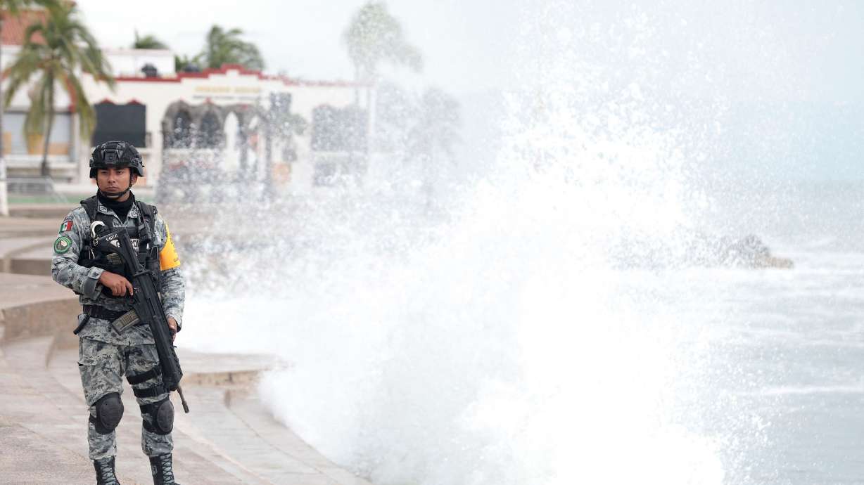 A member of Mexico's National Guard stands on the Puerto Vallarta boardwalk as waves crash against the shoreline ahead of the potential impact of Hurricane Simon in Puerto Vallarta, Jalisco state, Mexico. Hurricane Simon weakened to a Category 2 storm on Monday with sustained winds of 105 mph as it moved off Mexico's west coast, according to the U.S. National Hurricane Center.