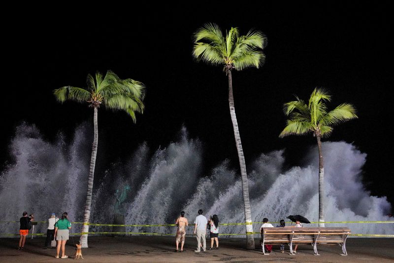 People watch waves crash against the waterfront promenade as Hurricane Simon approaches Mexico's Pacific coast in Puerto Vallarta, Mexico, October 11, 2026.