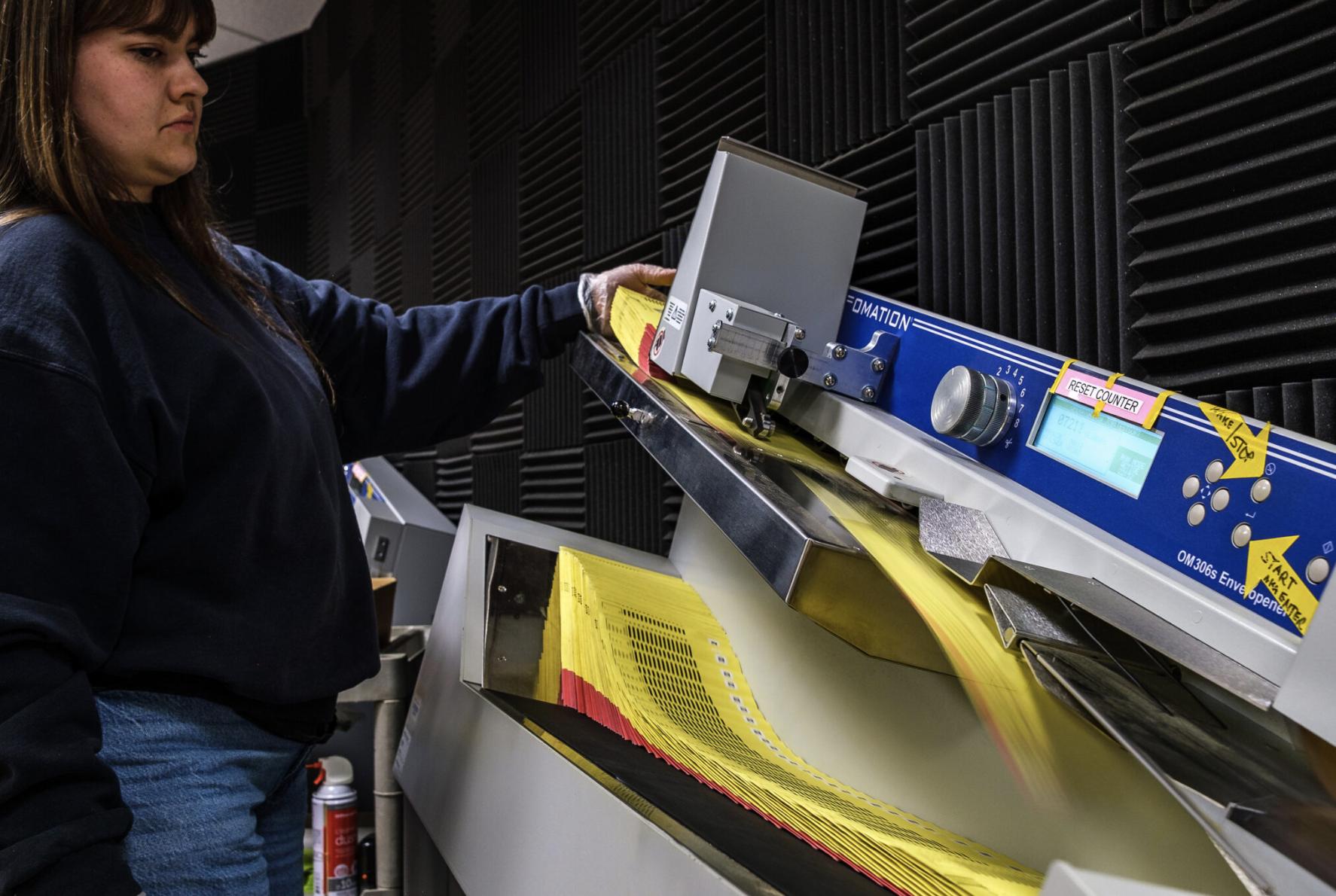Janalyn Christensen feeds paper ballots through an “envelopener” machine at the Salt Lake County Government Center on June 23.