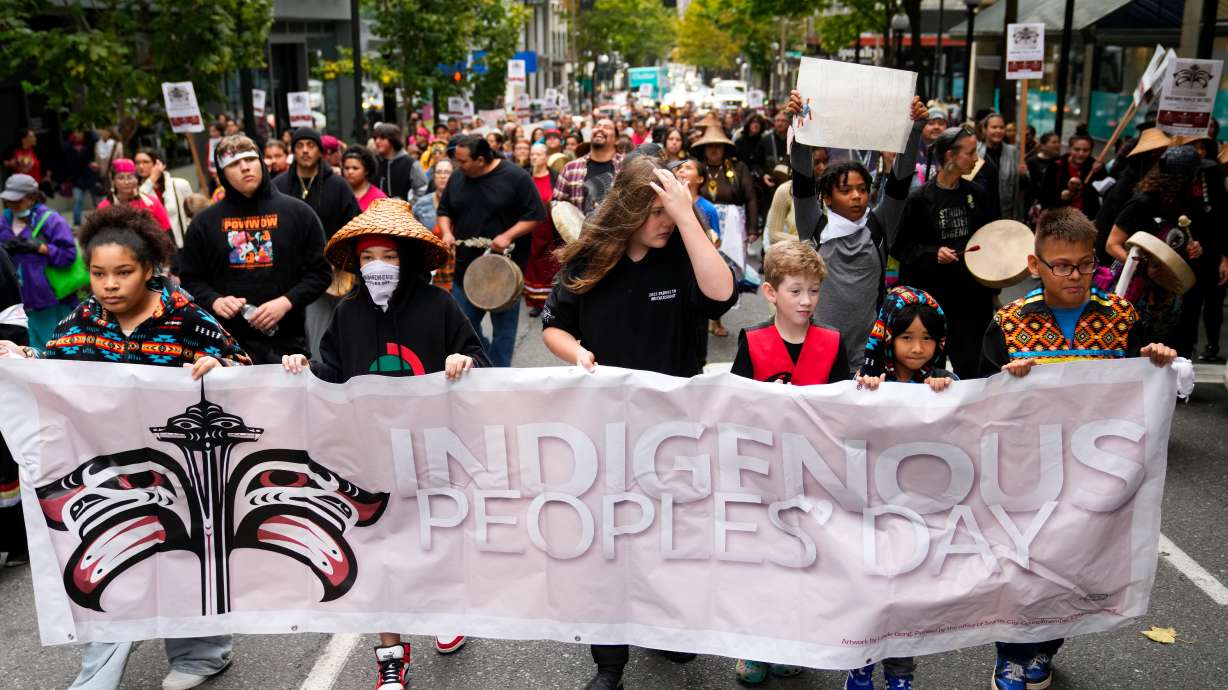 Young people hold a banner as they lead a celebratory march for Indigenous Peoples Day, Oct. 9, 2023, in Seattle.