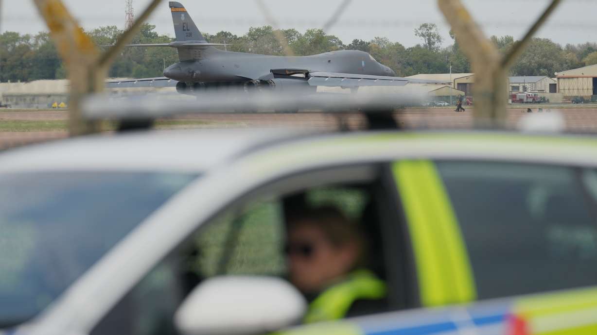 A B1 bomber prepares to take off as police officers guard a checkpoint near RAF Fairford air base, in Fairford, England, Sept. 29.