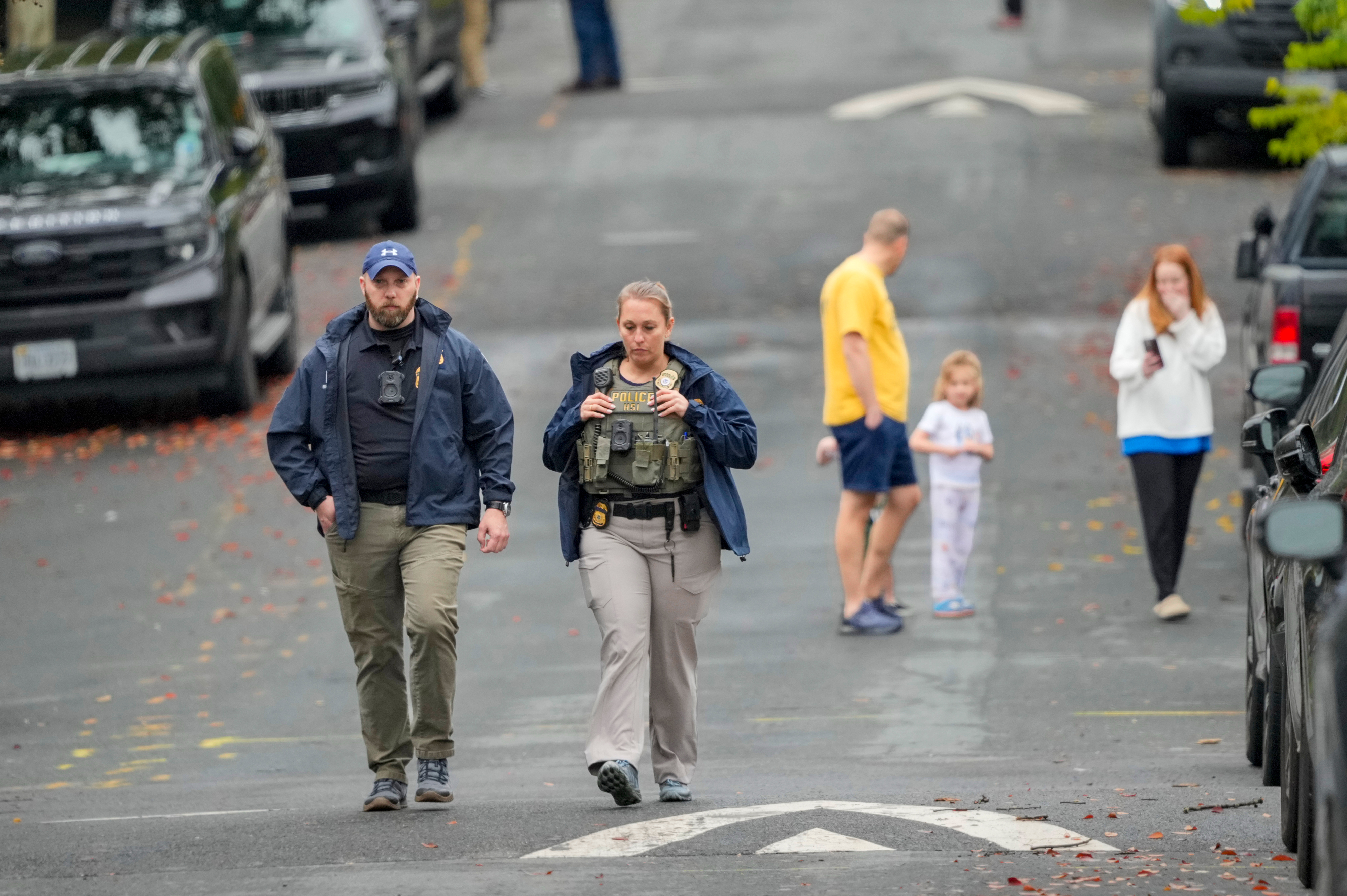 Homeland Security officers walk down 26th Street NE in Washington, early Monday, during an investigation at the residence of Rep. Ilhan Omar, D-Minn.