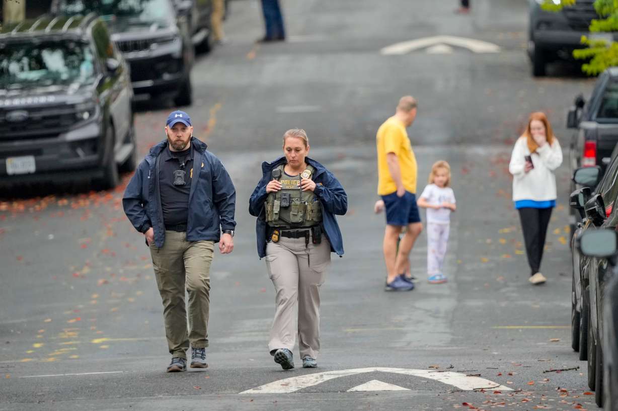 Homeland Security officers walk down 26th Street NE in Washington, early Monday, during an investigation at the residence of Rep. Ilhan Omar, D-Minn.