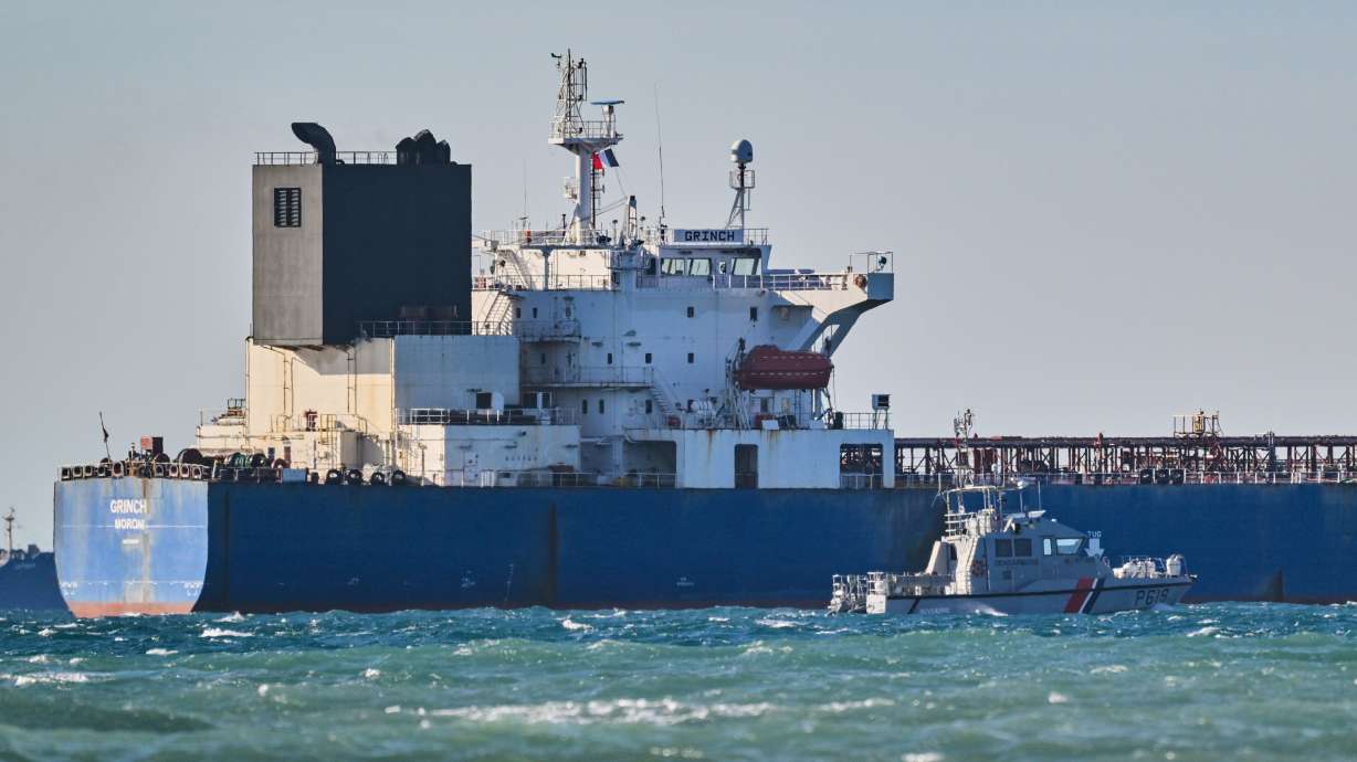 A navy vessel patrols next to a seized suspected Russian oil tanker in the Mediterranean Sea in Fos-sur-Mer, southern France, Jan. 26.