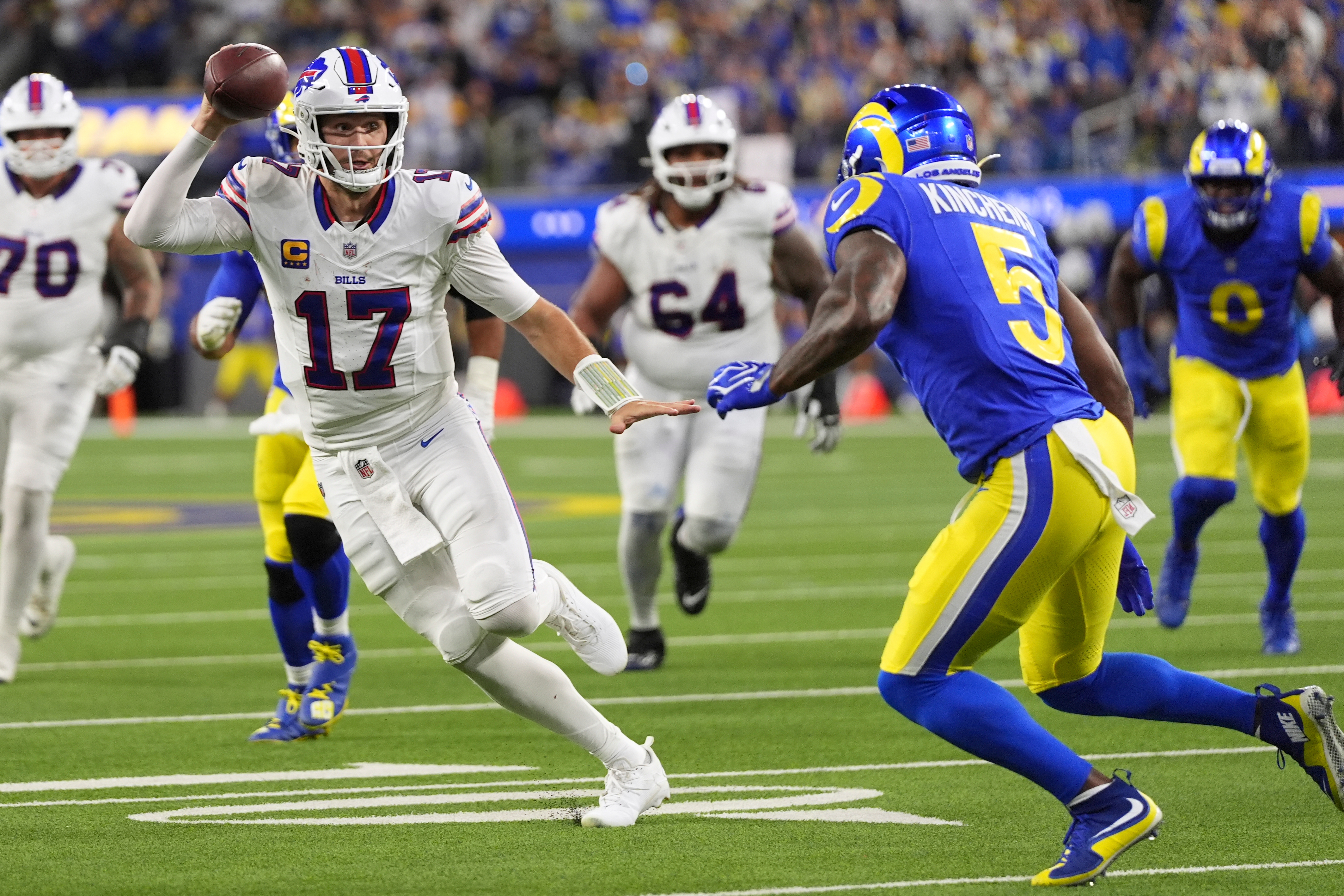 Buffalo Bills quarterback Josh Allen, left, runs the ball as Los Angeles Rams safety Kamren Kinchens defends during the second half of an NFL football game, Monday, Oct. 12, 2026, in Inglewood, Calif.