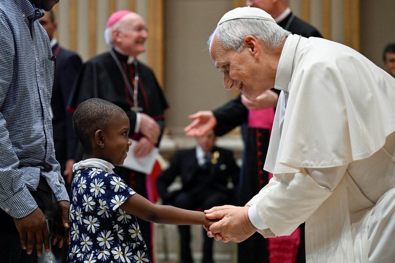 Pope Leo shakes hands with a child as he meets members and volunteers of the Circolo San Pietro at the Vatican, October 12, 2026.   Vatican Media/­Matteo Pernaselci/Handout via REUTERS     ATTENTION EDITORS - THIS IMAGE WAS PROVIDED BY A THIRD PARTY.     TPX IMAGES OF THE DAY