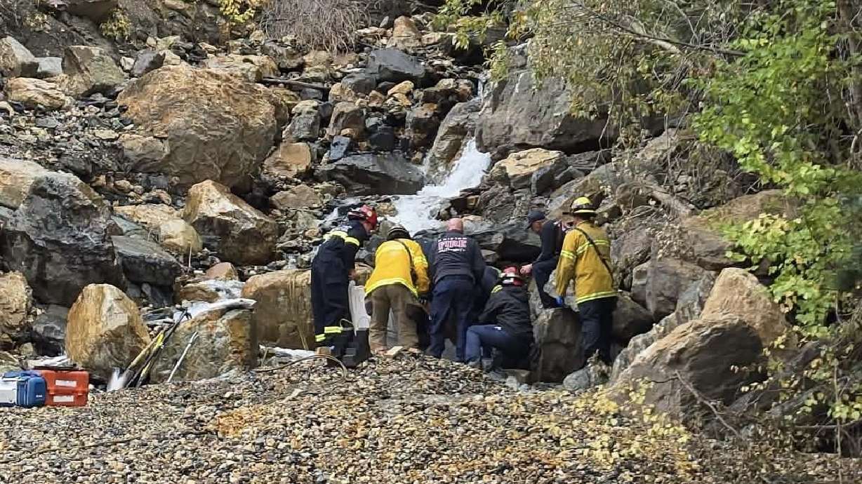 Rescuers attend to a man whose leg was caught underneath a boulder near the Storm Mountain area in Big Cottonwood Canyon on Sunday.