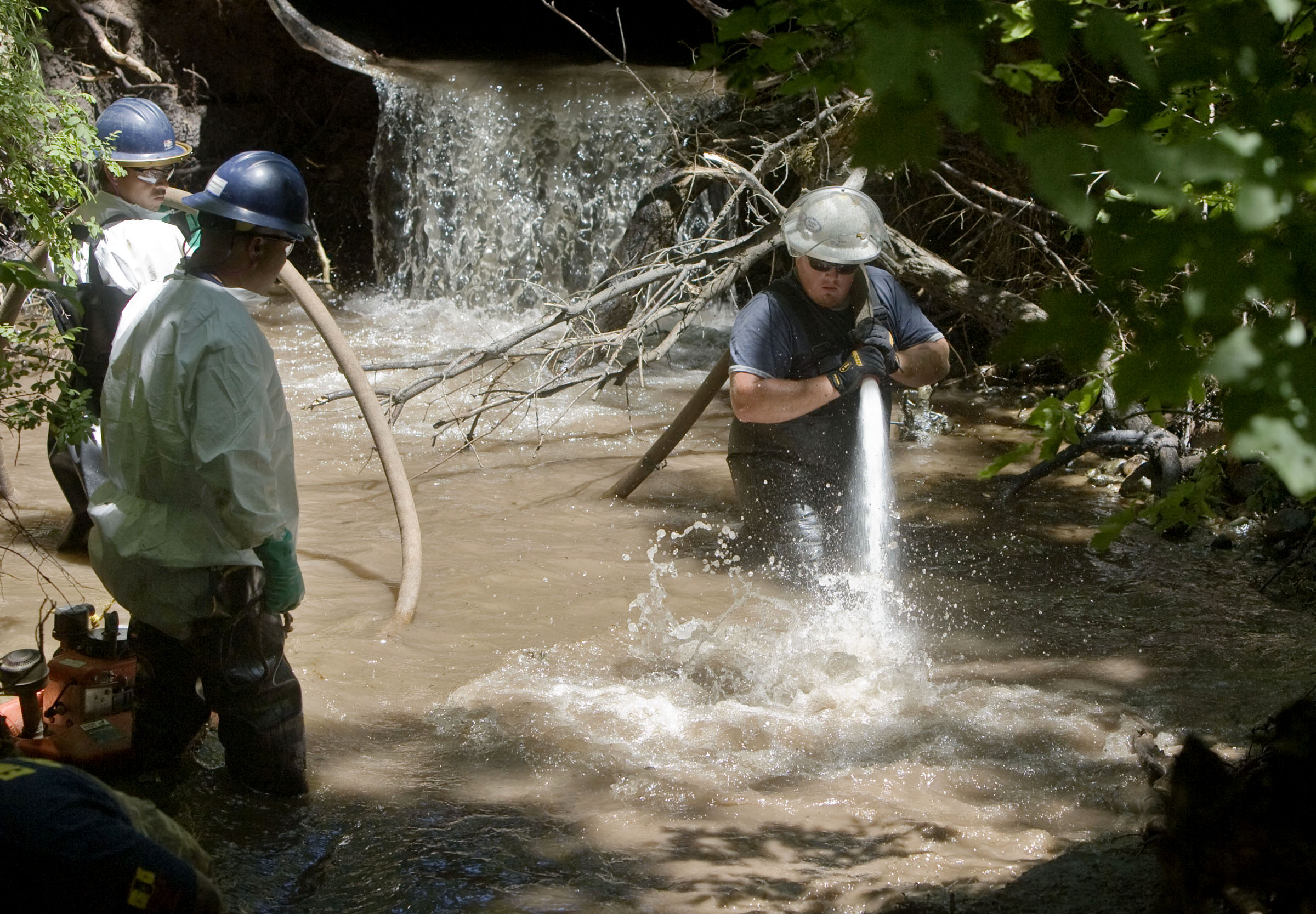 Members of the Red Butte Canyon Spill Unified Command Cleanup Operation crew uses a fire float to wash the bank of the Red Butte Creek behind the VA Hospital in Salt Lake City, Utah June 28, 2010. This group is made up of Chevron, The United States Environmental Protection Agency, the Utah Department of Environmental Quality, Salt Lake County and Salt Lake Valley Health Department after an oil spill in the creek.