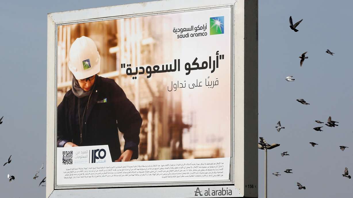 Birds fly over a billboard advertisement for Saudi Arabia's state-owned oil giant Aramco, with Arabic that reads, "Saudi Aramco, soon on stock exchange," in Jiddah, Saudi Arabia. Houthi rebels struck its headquarters on Wednesday, officials said.