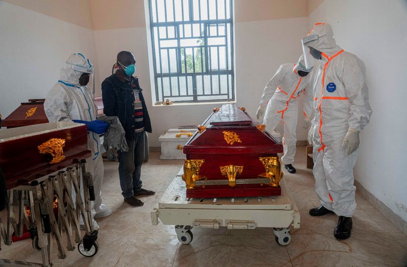 Members of the Safe and Dignified Burial (SDB) team from the Civil Protection of the Katwa health zone dressed in personal protective equipment (PPE) coffin the body of an eight month pregnant woman who died of Ebola and her fetus, at the morgue of the Kyaghala Hospital Centre, in the presence of some members of her family; as aid agencies intensify efforts to contain a new Ebola outbreak involving the Bundibugyo virus, in Butembo, North Kivu province, Democratic Republic of Congo, October 5, 2026.