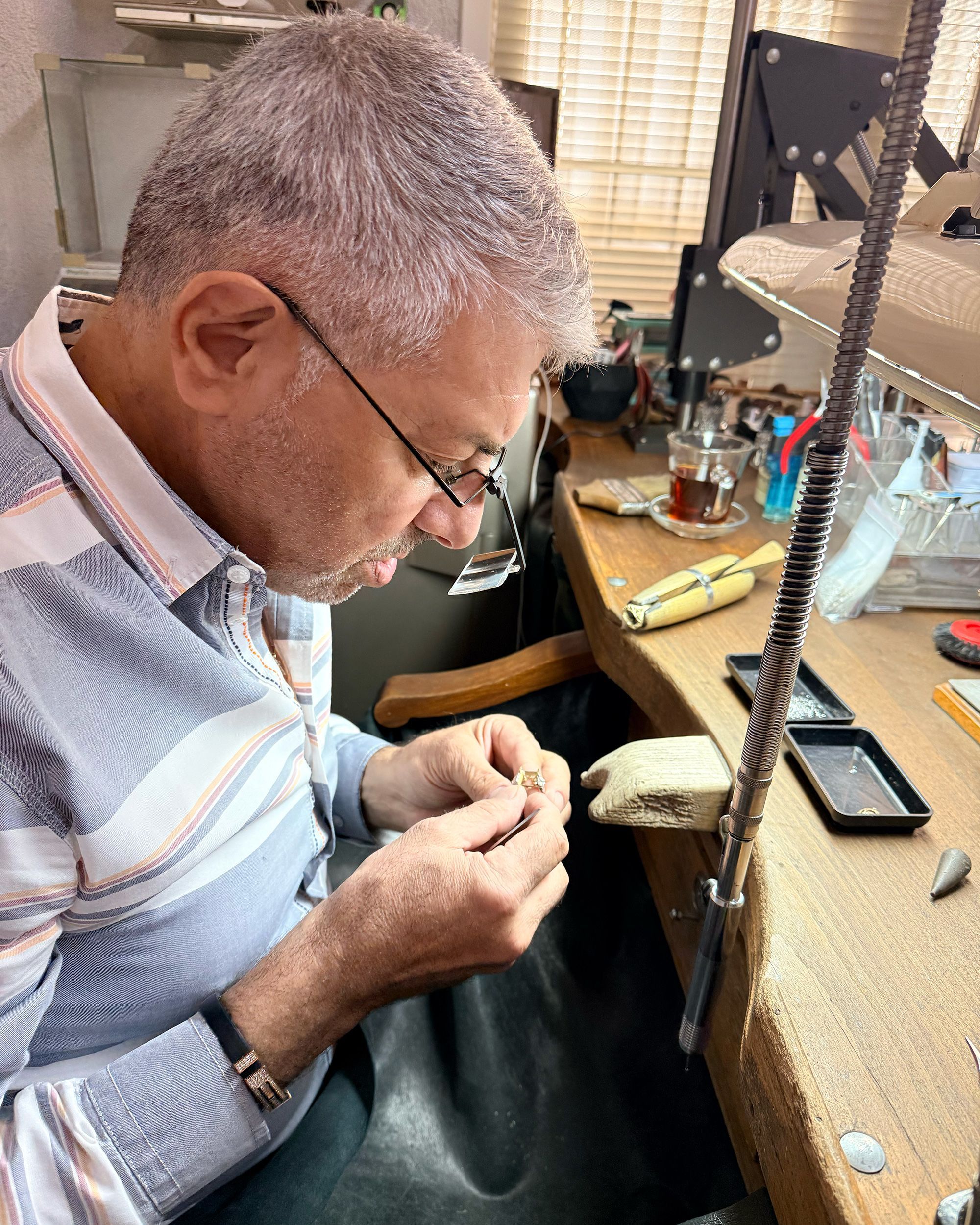 Hrant Zorbas, 66, a “mihlama,” or stone-setting master, checks a gold ring setting before placing a ruby at its center.