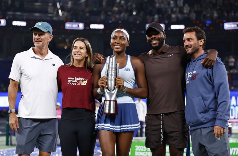 Tennis - WTA 1000 - Wuhan Open - Optics Valley International Tennis Center, Wuhan, China - October 12, 2025 Coco Gauff of the U.S. poses with the trophy and team after winning the final against Jessica Pegula of the U.S.