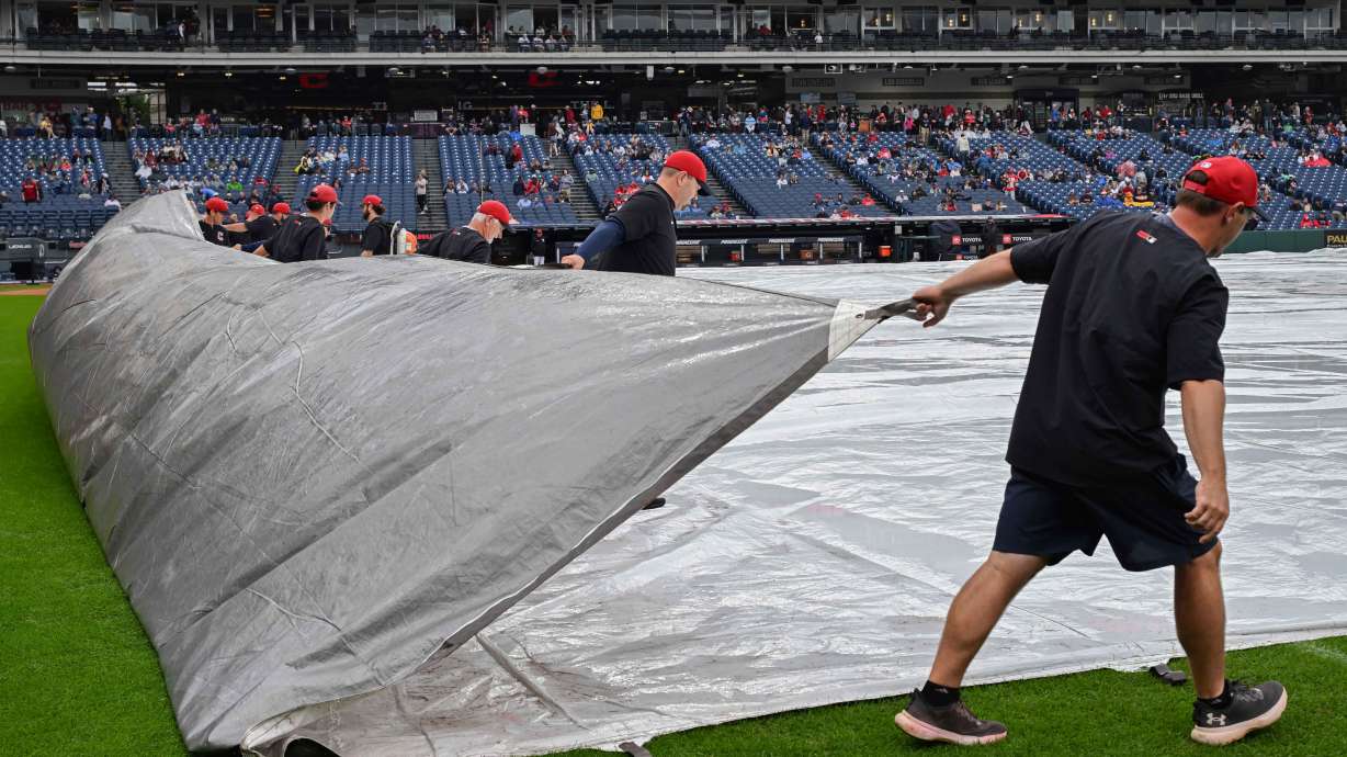 The Progressive Field grounds crew removes a tarp after a rain delay before a baseball game between the Athletics and the Cleveland Guardians, Sunday, Sept. 20, 2026, in Cleveland.