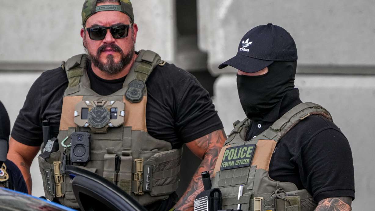 Immigration and Customs Enforcement officers stand at the scene where a man was shot in his vehicle by an ICE officer Sept. 20, 2026, in Austin, Texas.