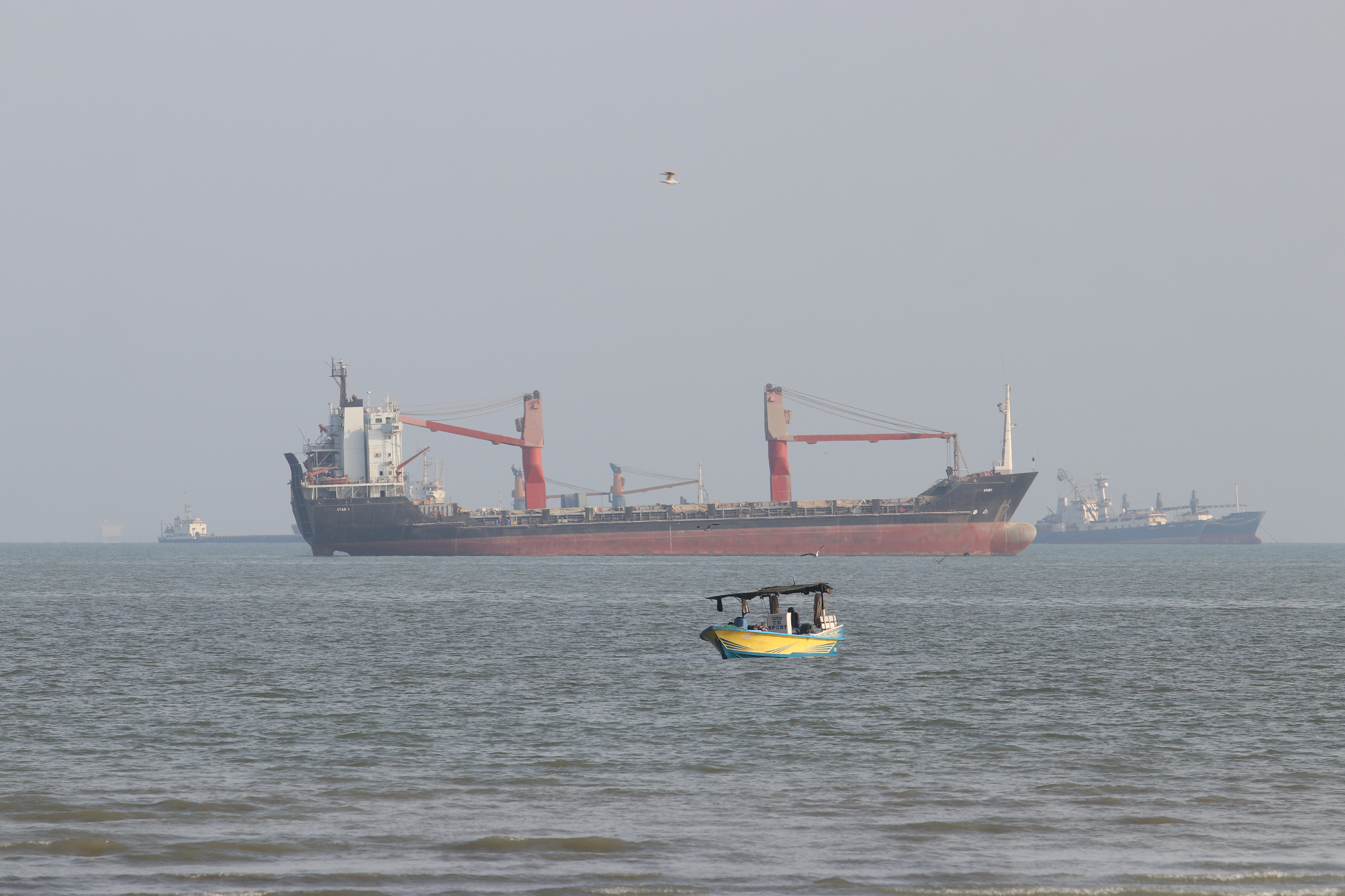A boat floats as commercial vessels appear anchored in the Strait of Hormuz off Bandar Abbas, Iran, Oct. 13. Iran's government said seven tankers were hit in the strait on Wednesday, raising fears of a return to all-out war.