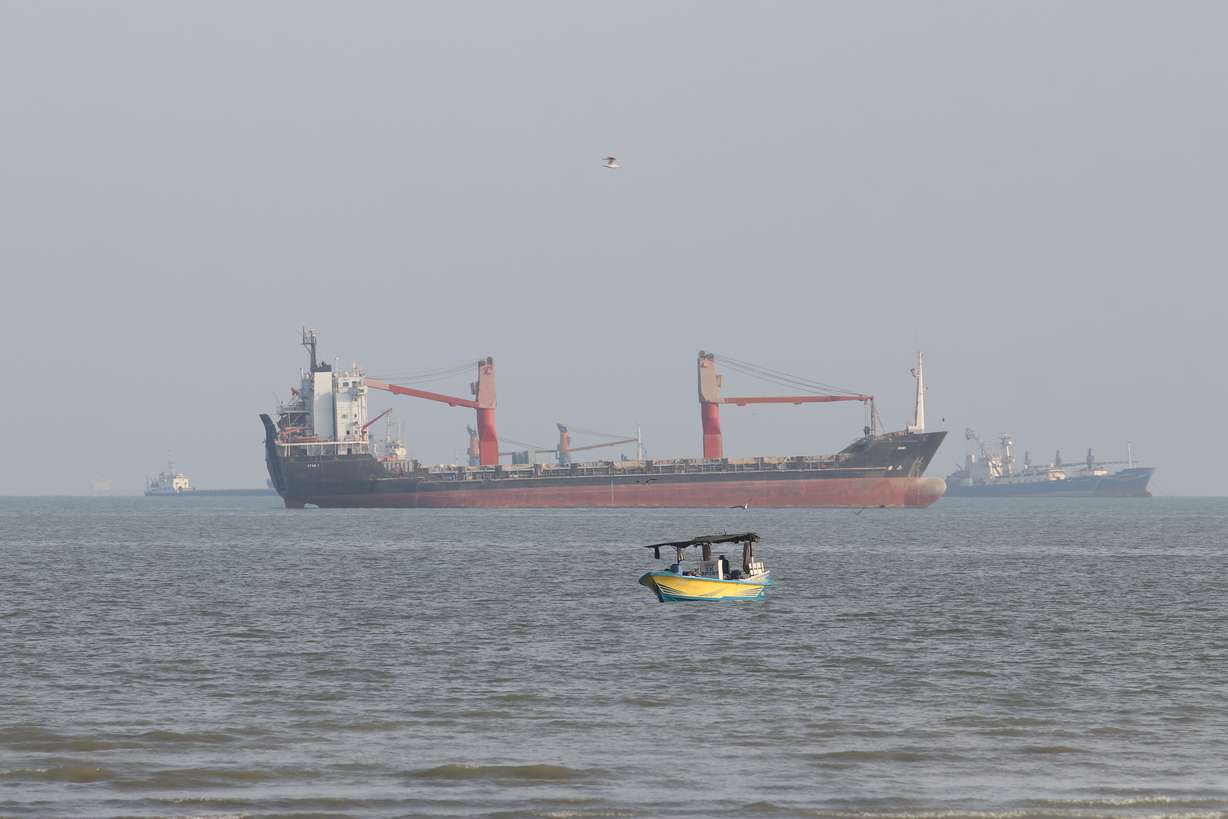 A boat floats as commercial vessels appear anchored in the Strait of Hormuz off Bandar Abbas, Iran, Oct. 13. Iran's government said seven tankers were hit in the strait on Wednesday, raising fears of a return to all-out war.