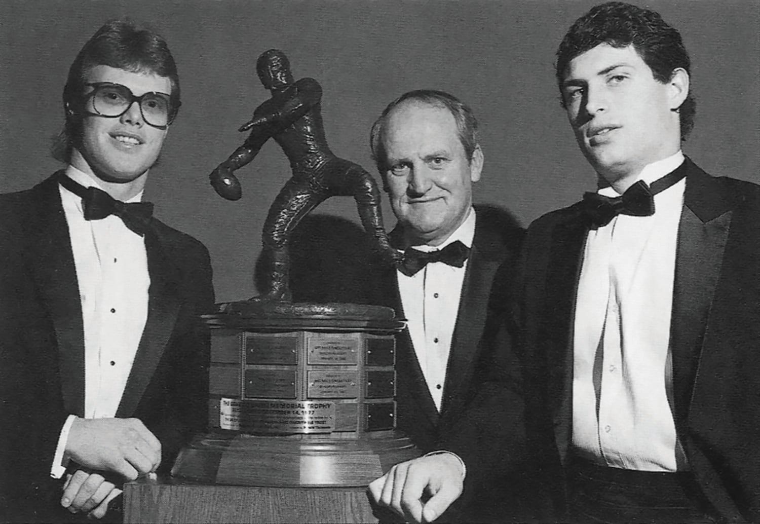 BYU quarterbacks Jim McMahon and Steve Young with head coach LaVell Edwards at the Davey O'Brien Awards ceremony. The school has a long tradition of being a quarterback factory.