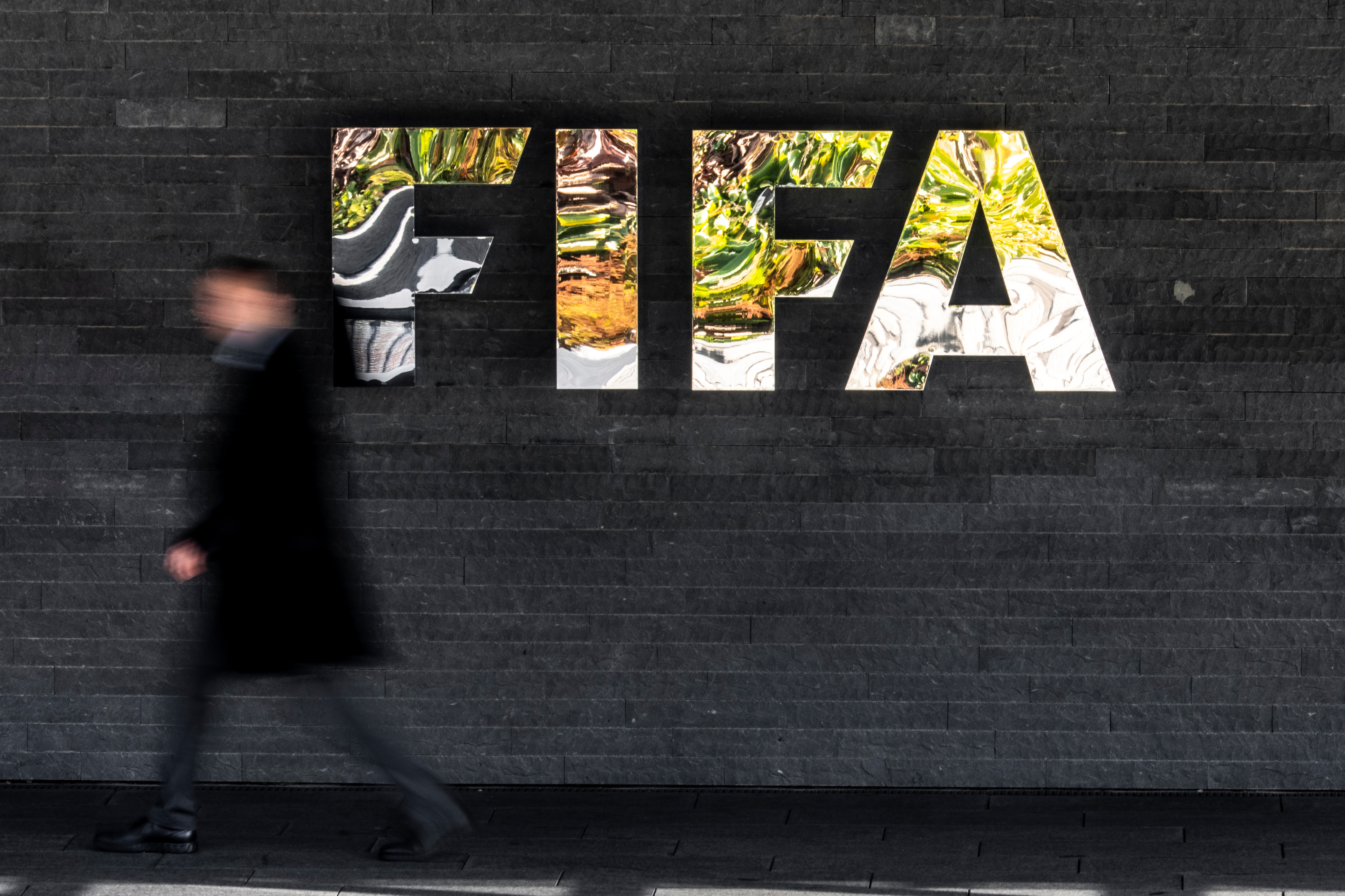 A man walks past a FIFA sign at the headquarters during the FIFA council meeting, in Zurich, Switzerland, Thursday, Oct. 15, 2026. 