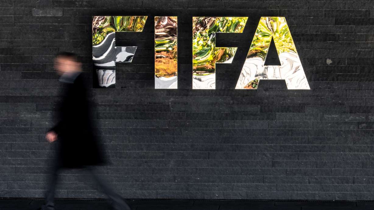 A man walks past a FIFA sign at the headquarters during the FIFA council meeting, in Zurich, Switzerland, Thursday, Oct. 15, 2026.