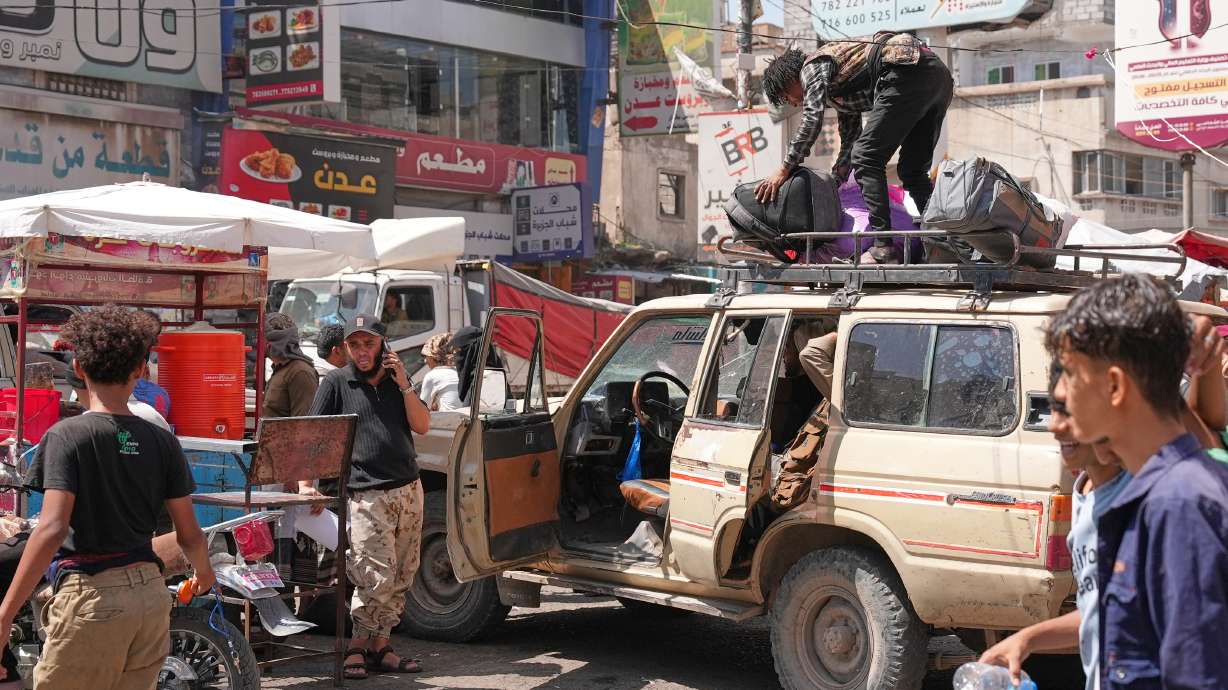 People crowd at a minibus station used by displaced to leave the city, in Taiz, Yemen, Thursday. At least two people were killed and six more were wounded in explosions near the Yemeni presidential palace.