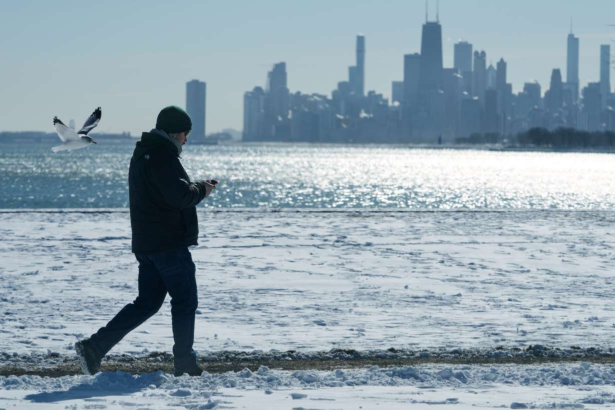 A person walks near the snow-covered sand at Lake Michigan in Chicago, Jan. 28. While El Nino is expected to be at its strongest this winter, it doesn't necessarily mean an increase of rain or snow at a certain location.