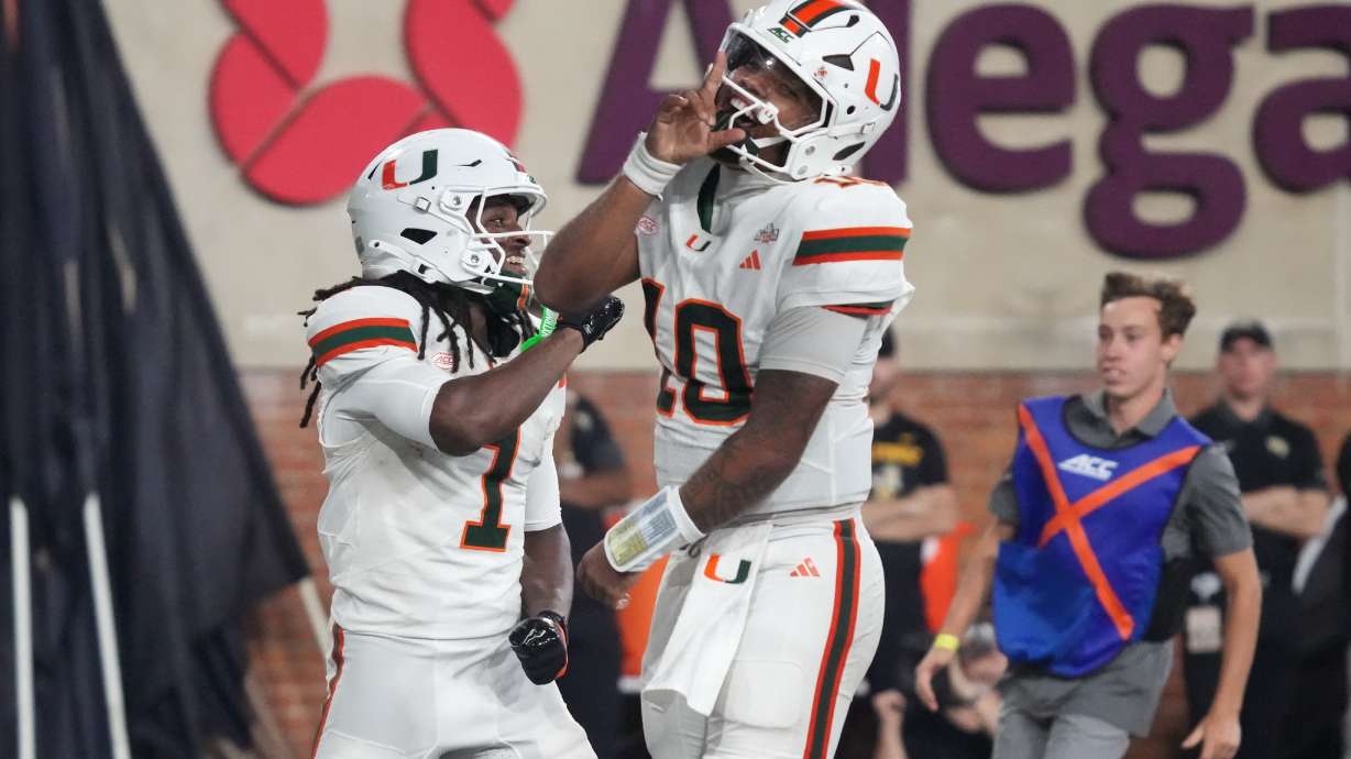 Miami quarterback Darian Mensah (10) and wide receiver Malachi Toney (1) celebrate after Toney's touchdown against Wake Forest during the second half of an NCAA college football game in Winston-Salem, N.C., Friday, Sept. 18, 2026.