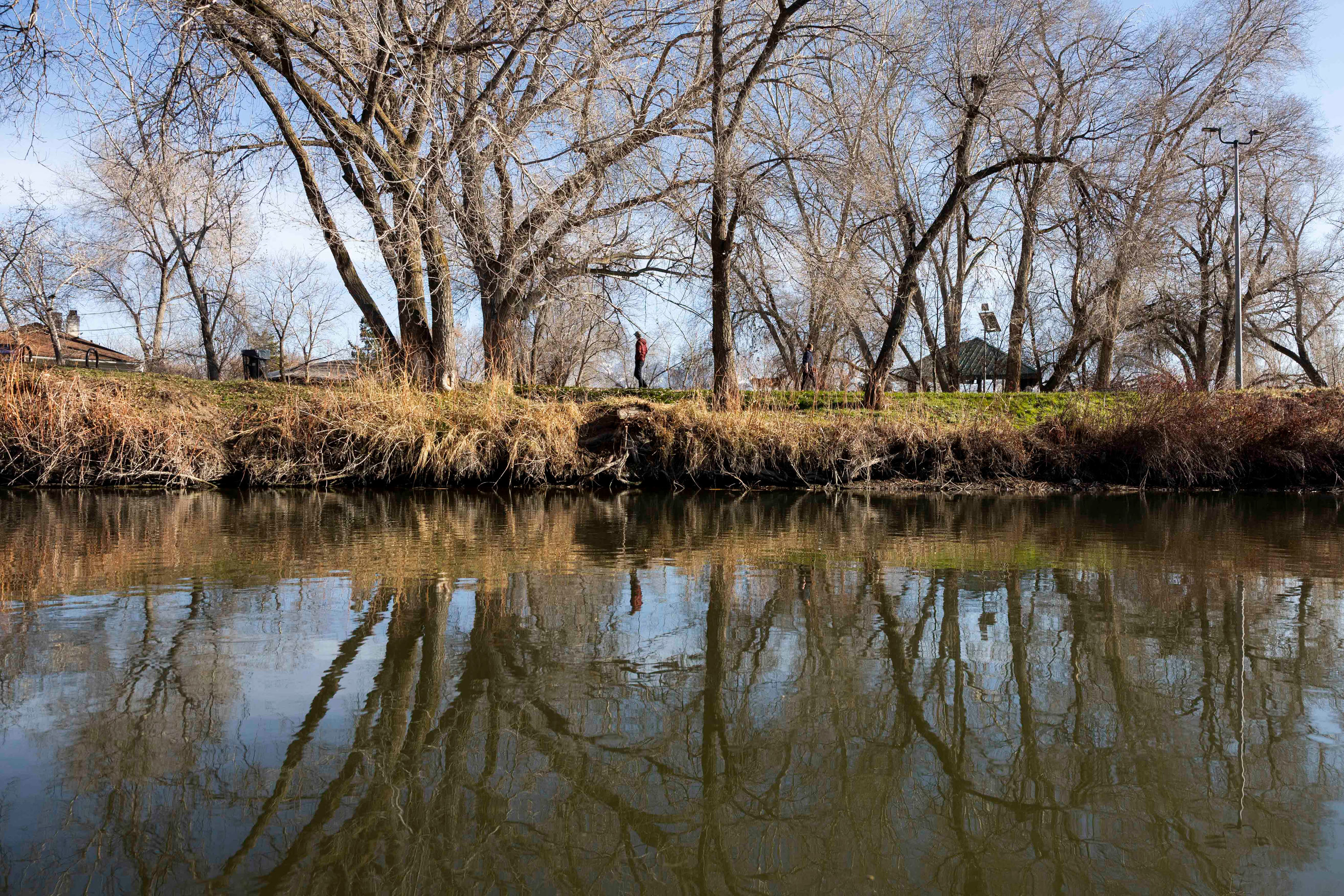 People walk along the Jordan River Trail in Salt Lake City on Monday, Feb. 2.