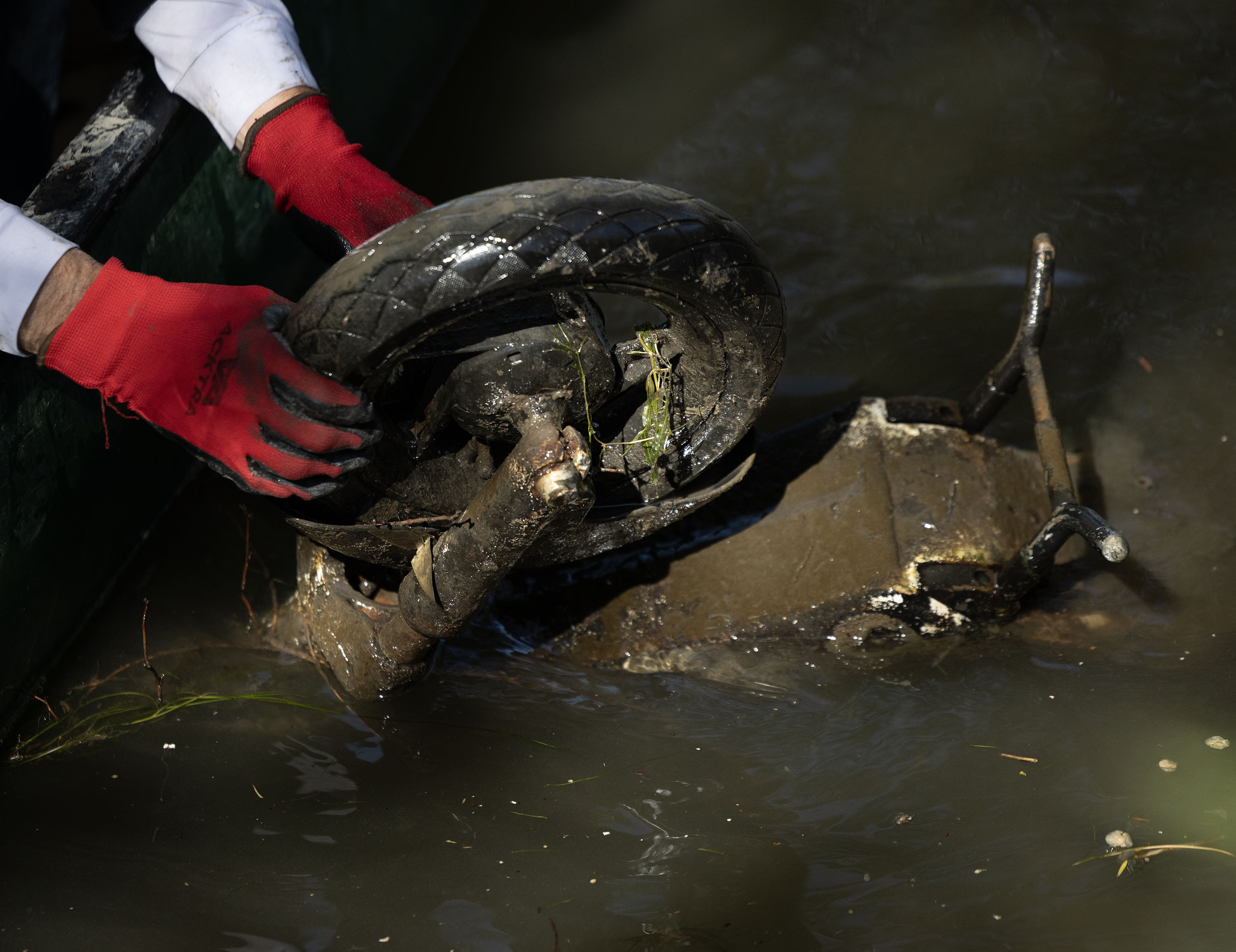 A Lime scooter is hoisted from the Jordan River during the annual Larry H. Miller Week of Service in Salt Lake City on Tuesday, April 28, 2026.