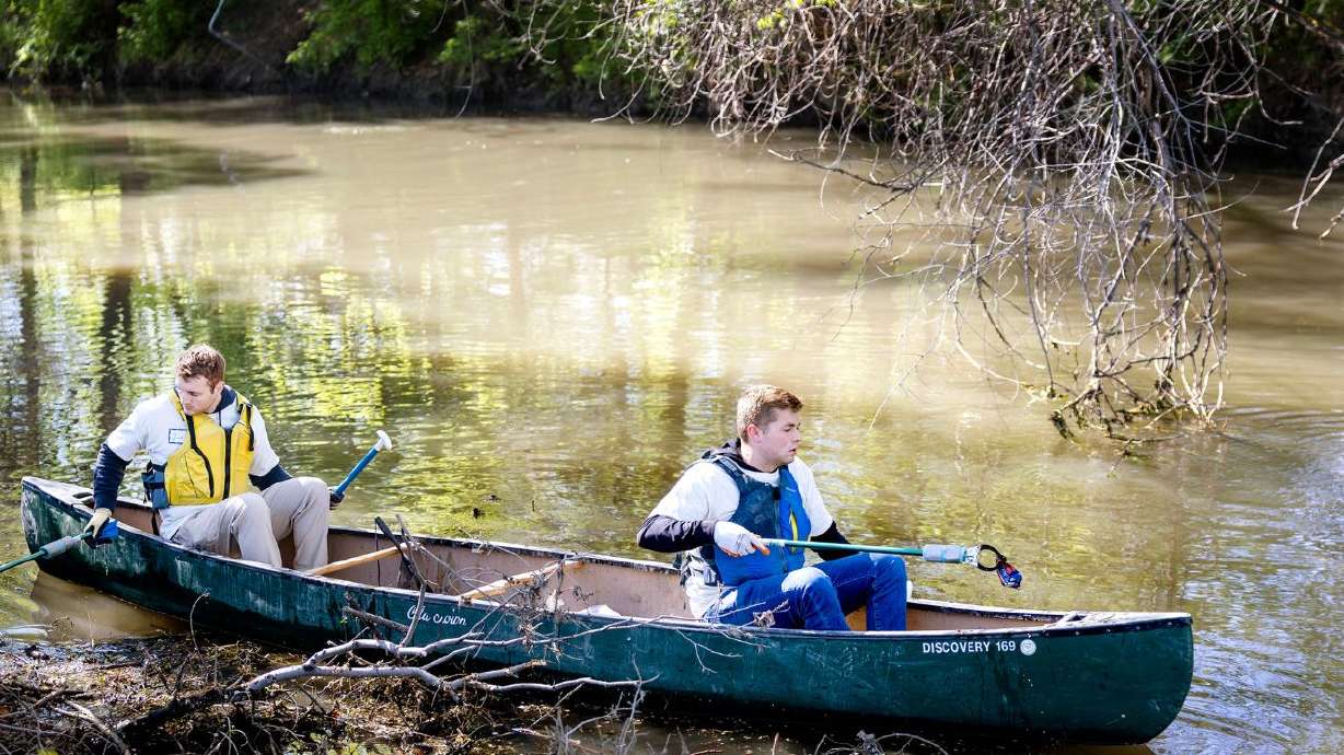 Jon Christensen, left, and Porter Roddy pick up trash in the Jordan River in Salt Lake City on April 28. The final volunteer opportunity for 2026 is Oct. 24.