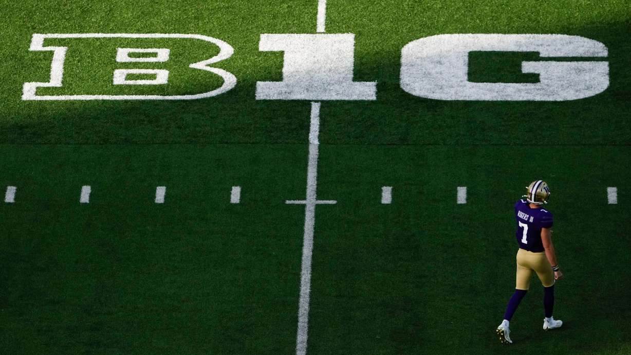 Washington quarterback Will Rogers walks on the field near a Big Ten logo during the first half of an NCAA college football game against Northwestern, Sept. 21, 2024, in Seattle.