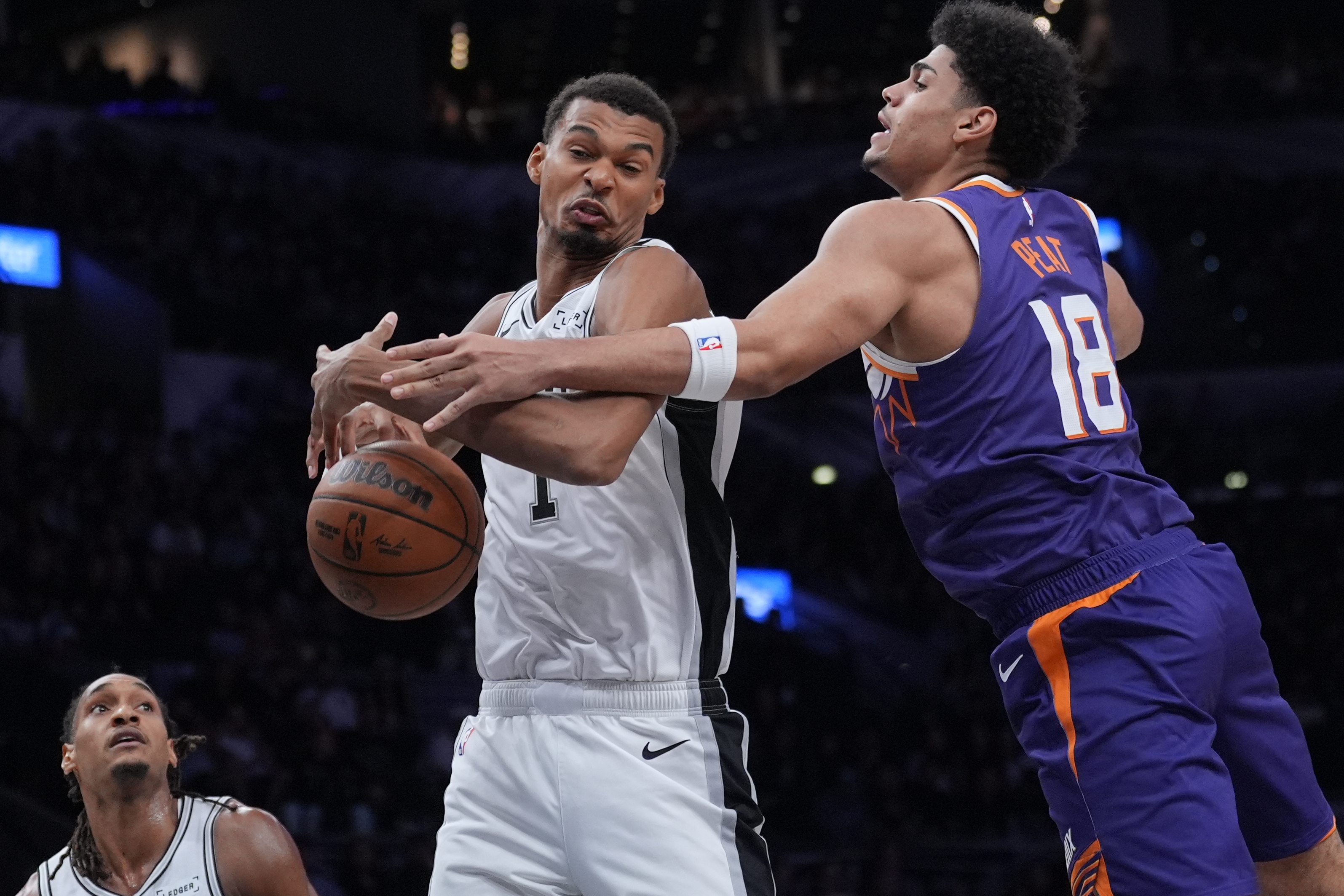 San Antonio Spurs forward Victor Wembanyama (1) and Phoenix Suns forward Koa Peat (18) battle for a rebound during the first half of a preseason NBA basketball game in San Antonio, Wednesday, Oct. 14, 2026. 