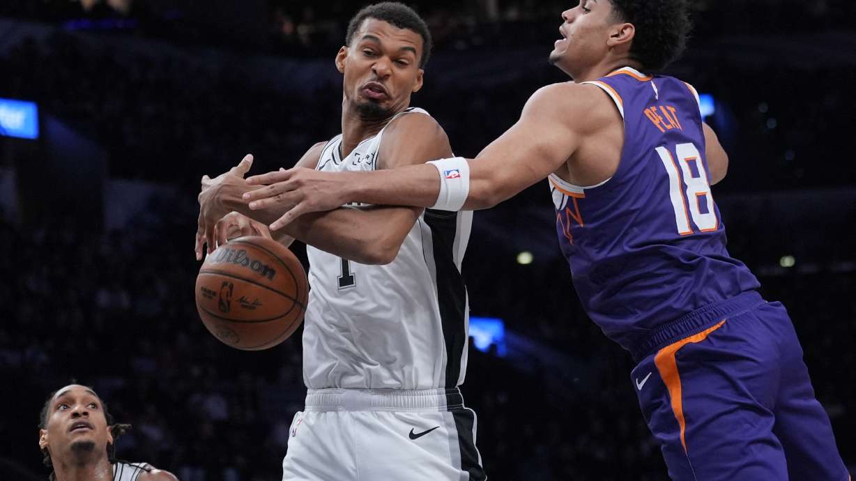 San Antonio Spurs forward Victor Wembanyama (1) and Phoenix Suns forward Koa Peat (18) battle for a rebound during the first half of a preseason NBA basketball game in San Antonio, Wednesday, Oct. 14, 2026.