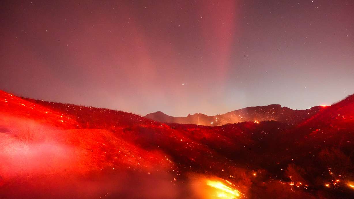 Hot spots glow across a hillside during the Bryson Fire in Malibu, Calif., Thursday. Several brush fires are burning in Southern California as some have evacuated and many wake up without power.