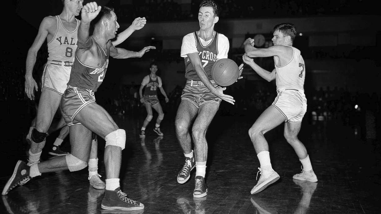 FILE - Bob Cousy, Holy Cross forward, second from right, intercepts a pass intended for Tony Lavelli, (8) of Yale, left, in first period of an NCAA college basketball game Feb. 19, 1949, in New Haven, Conn. Rob McMullen of Holy Cross, left, comes in on the play. Art Fizgerald, (7) of Yale is at right.