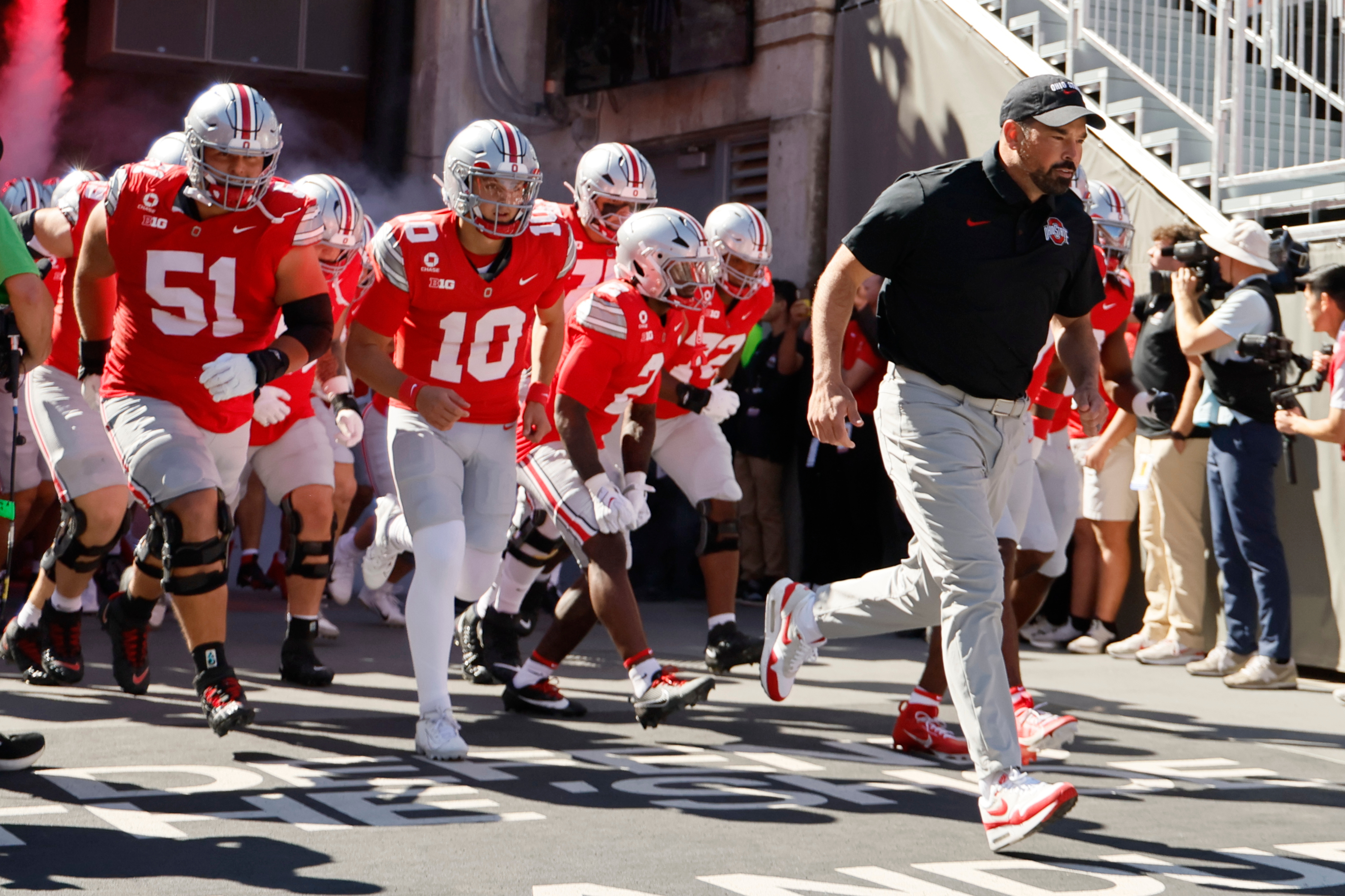 Ohio State head coach Ryan Day, right, leads the team onto the field for the start of an NCAA college football game against Illinois, Saturday, Sept. 26, 2026, in Columbus, Ohio. 