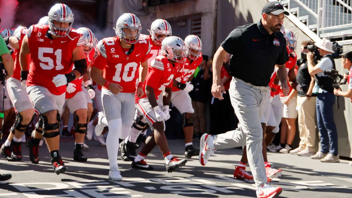 Ohio State head coach Ryan Day, right, leads the team onto the field for the start of an NCAA college football game against Illinois, Saturday, Sept. 26, 2026, in Columbus, Ohio.