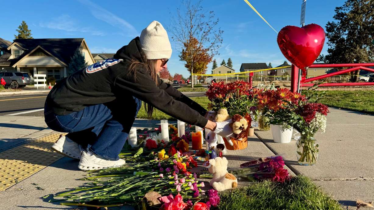 A person places flowers at a makeshift memorial on the other side of Silver Rail Elementary School in Bend, Ore., on Friday, a day after a deadly shooting. Gov. Tina Kotek praised a local who "heroically" helped end the shooting on Thursday.