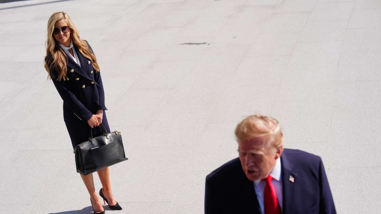 President Donald Trump speaks to the reporters as he walks to board Marine One on the South Lawn of the White House, Tuesday, in Washington, as White House press secretary Katie Zacharia looks on. Zacharia was "let go" from the role on Friday.