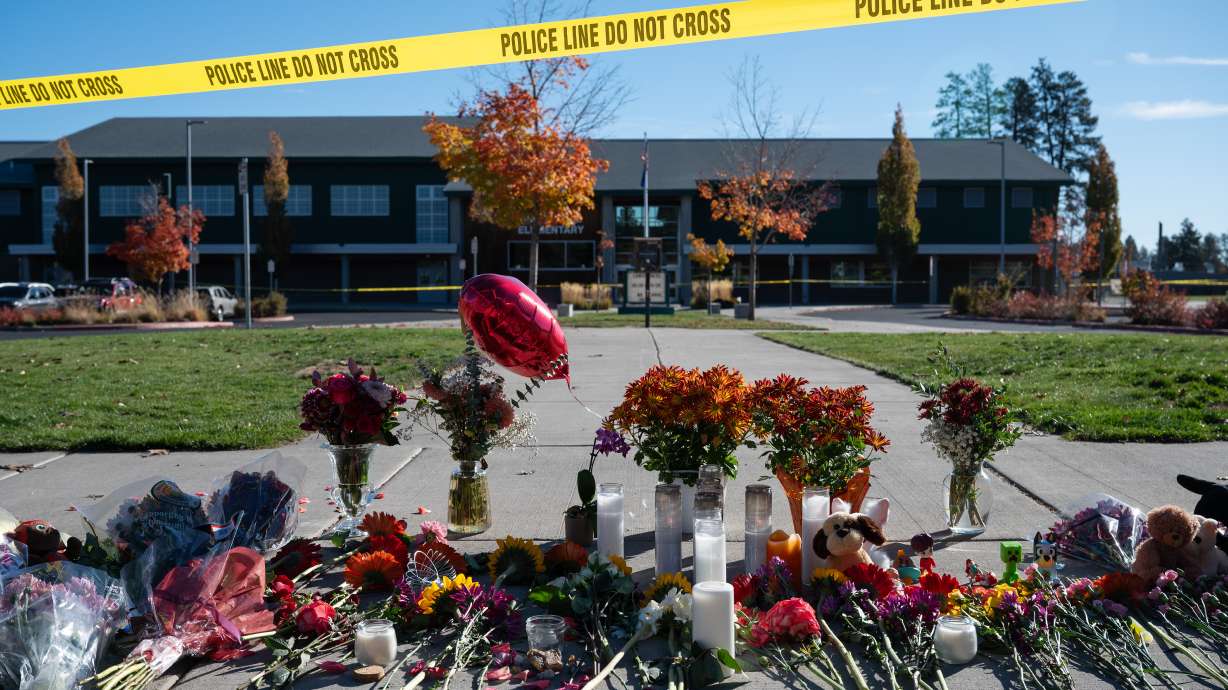 Flowers and candles are seen at a makeshift memorial outside Silver Rail Elementary School in Bend, Ore., Friday, a day after a deadly shooting. A woman says her son was the man who stopped the shooter, and he has two daughters at the school.