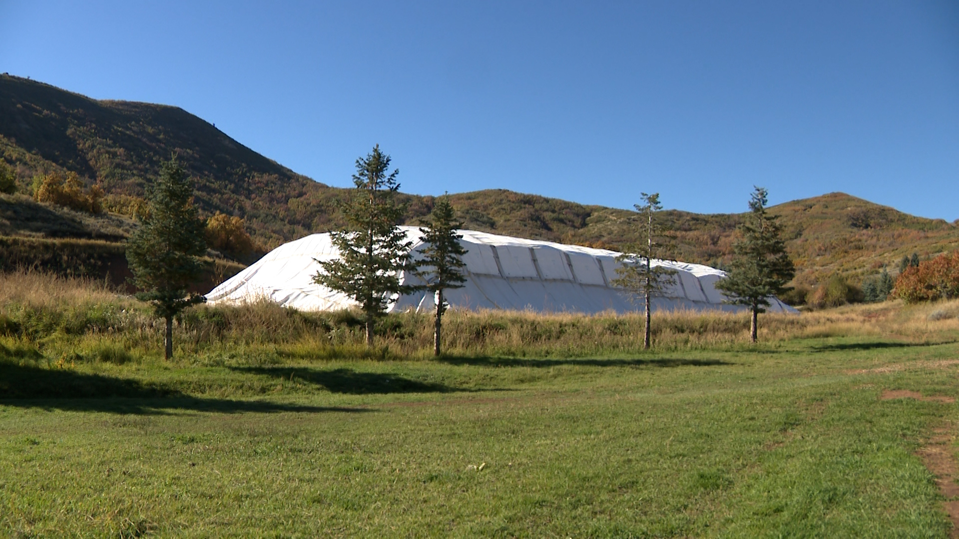 Earlier this year, crews at Soldier Hollow made a pile of snow roughly the size of a football field and about 25 feet deep. They then covered it with special insulating tarps and mats designed to keep the snow from melting during the warmer months.