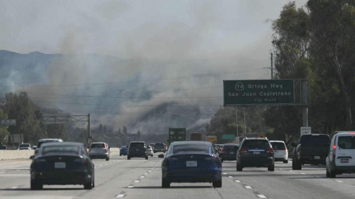 Cars drive along Interstate 5 toward the Norte Fire in San Juan Capistrano, California, on Friday. Evacuation orders have been issued for parts of Orange County.