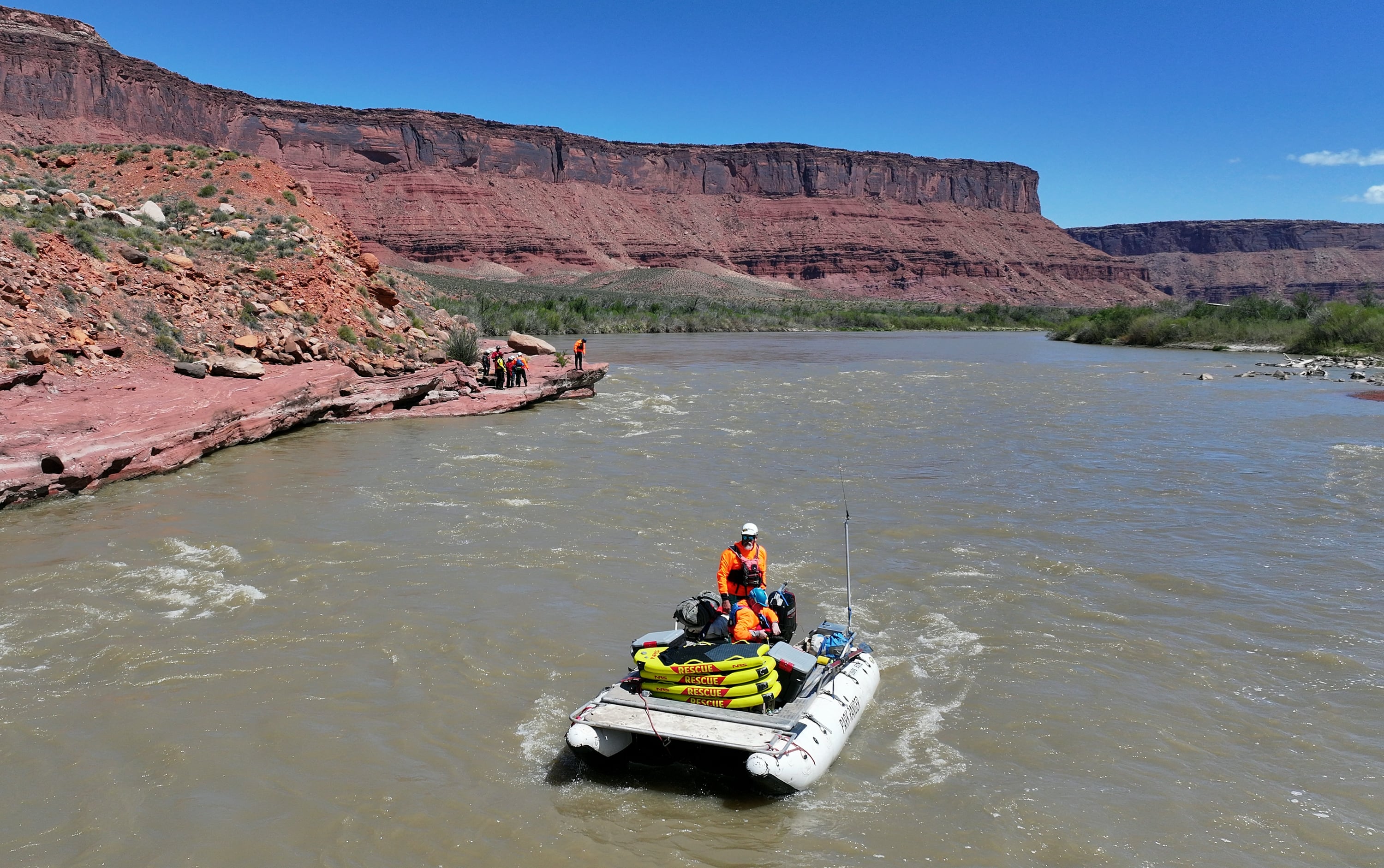 Canyonlands National Park backcountry river ranger and former river district ranger Steve Young, nicknamed Tberry, stands to drive a boat while teaching a Swift Water Incident Management training course on the Colorado River near Onion Creek rapids in Grand County on April 29, 2025. Bill Campbell, emergency room physician and medical director for Great Smoky Mountains National Park, the Obed Wild and Scenic River, and the Big South Fork National River and Recreation Area, sits on the boat with him.